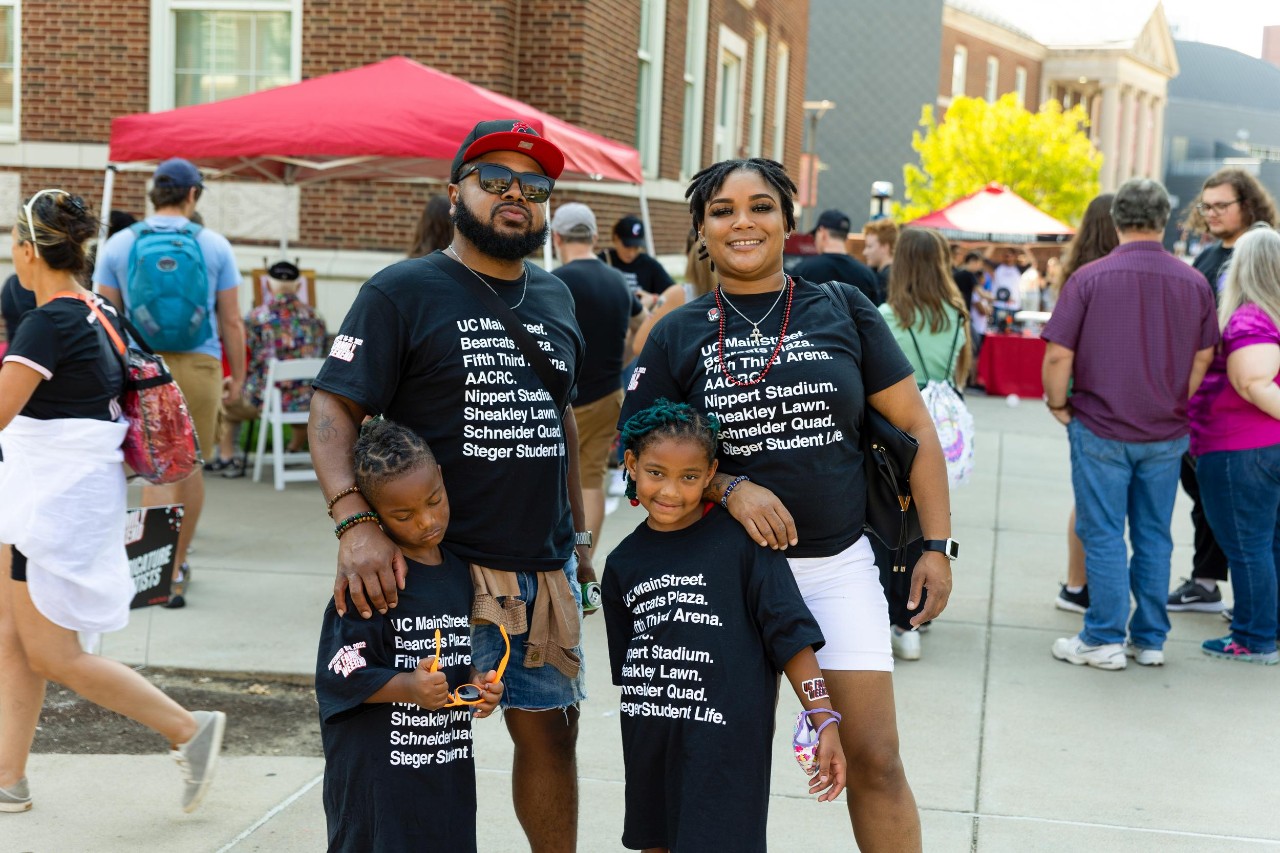 Photo of a family at UC for Family Weekend, posing.