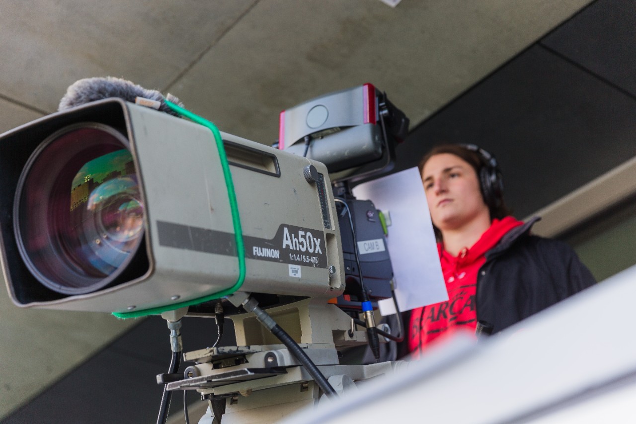 UC student working a camera as part of the sports production program.