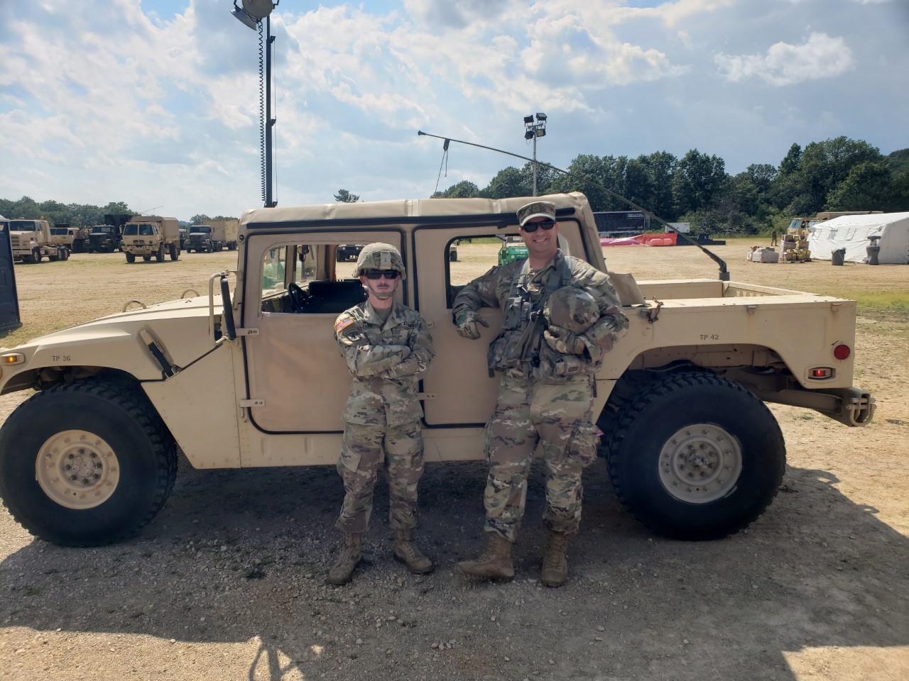 Daniel Peat and a fellow soldier stand next to a Humvee.