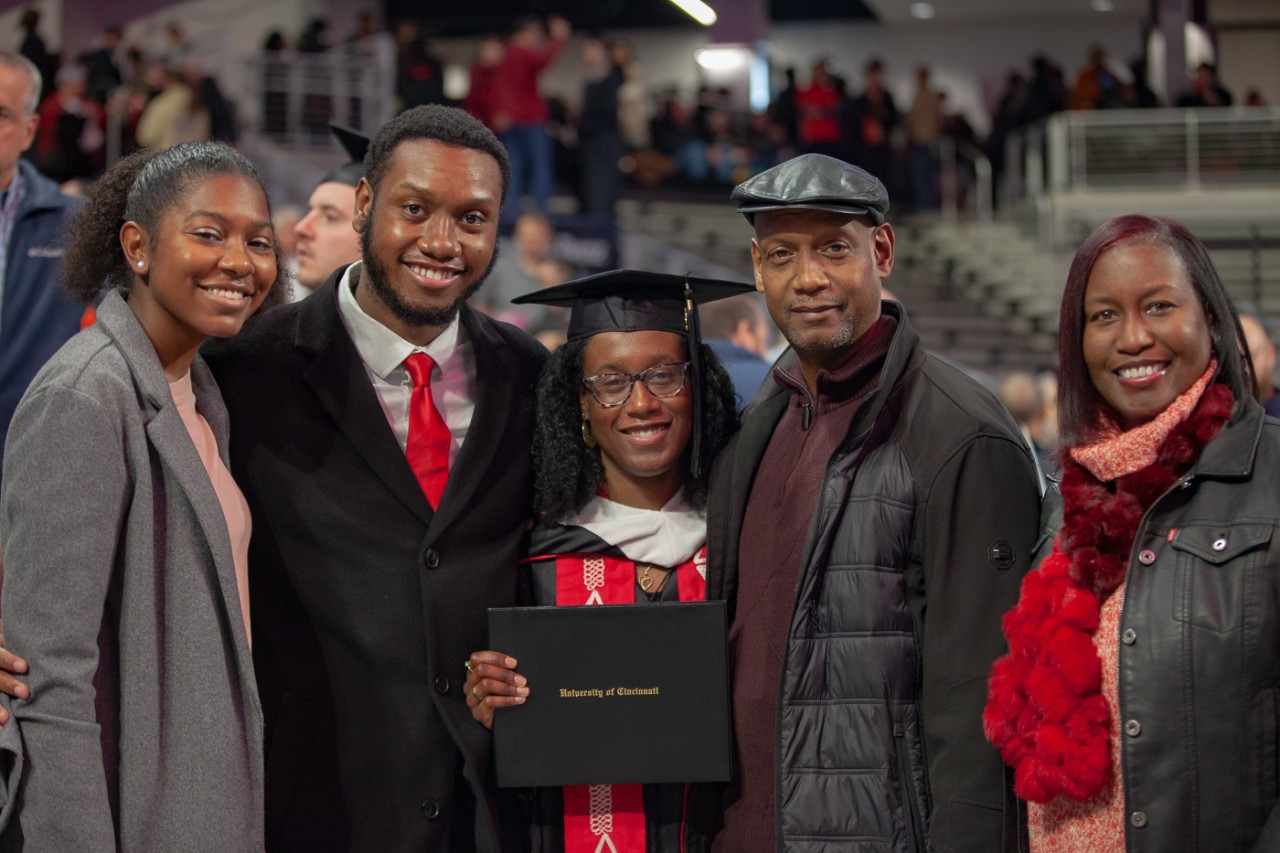 A family poses with a grad in Fifth Third Arena.