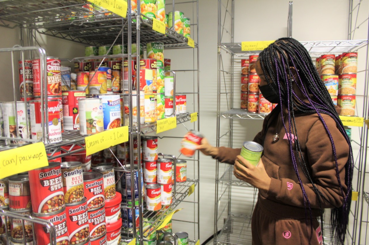 Student stocks pantry shelves