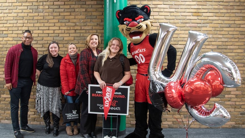 Brooke Hewitt smiling with family group and bearcat mascot