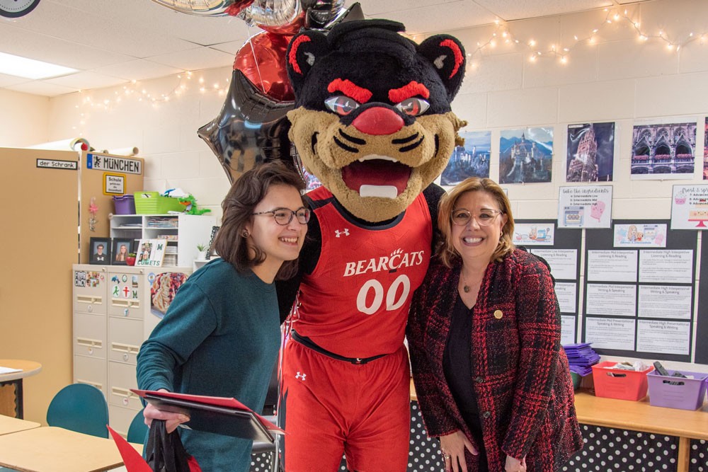 Ava Hartmann smiling with bearcat mascot and Dean Lightner