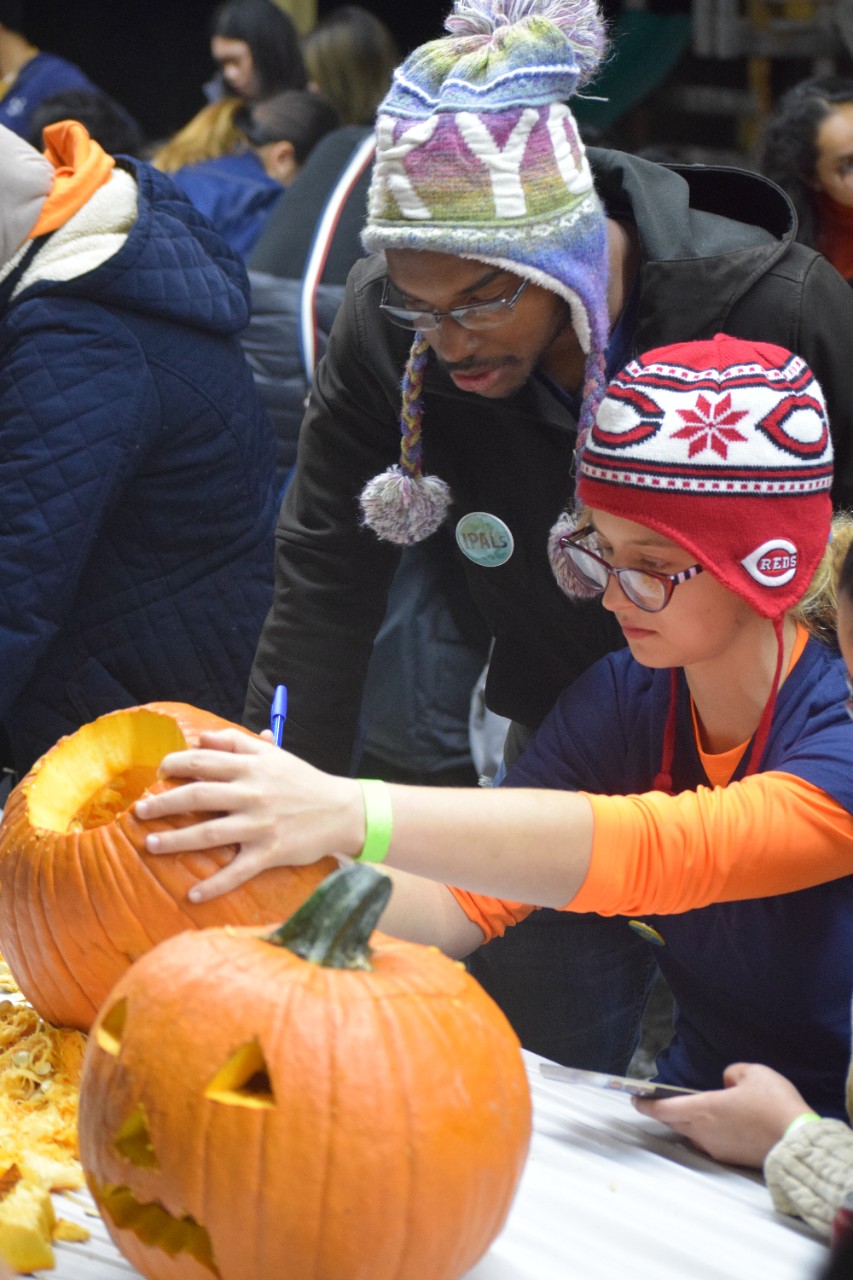 As undergraduate students, Zoe Lee and Christian Charles carve pumpkins at an IPALs event. 