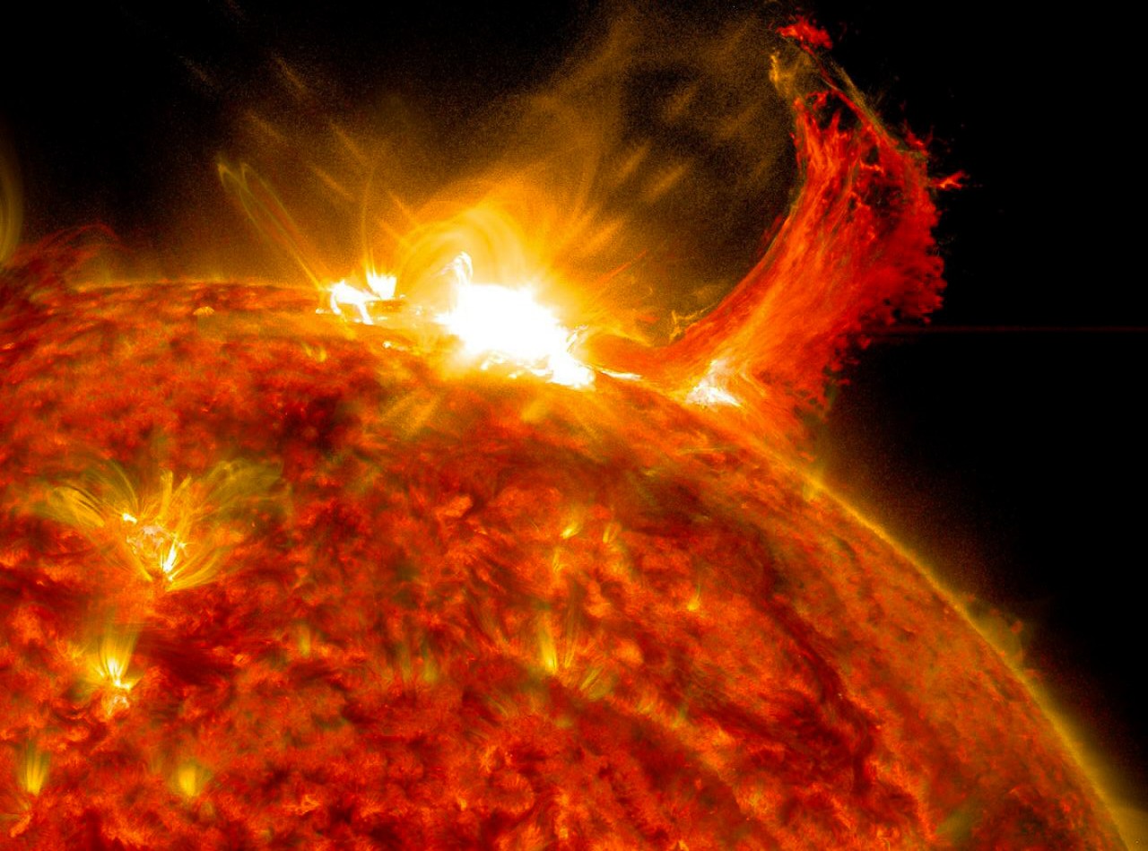 A solar flare erupts from the surface of the sun.
