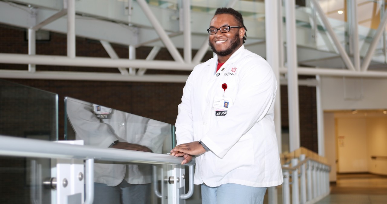 UC medical student William Smith stands on bridge in lobby of UC College of Medicine.