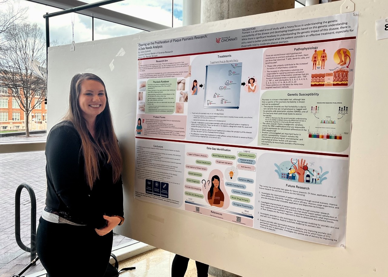 Woman stands next to poster at a pharmacy conference.
