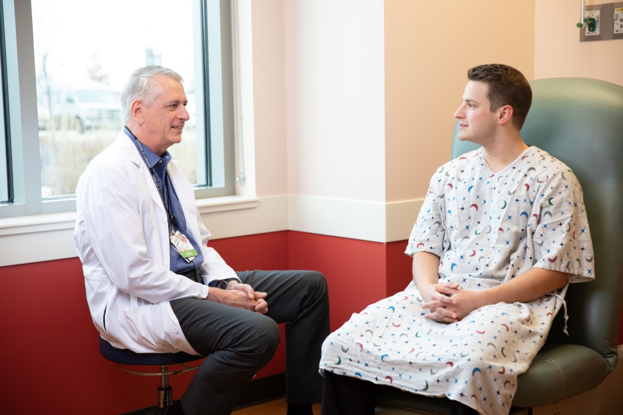 Dr. Breneman sits and talks with a patient