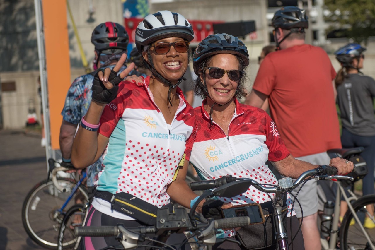 two people wearing bike helmets