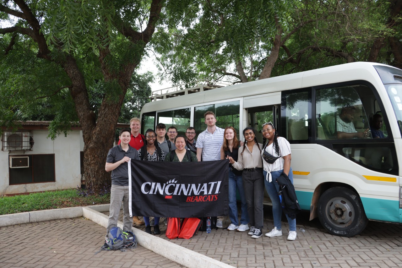 CEAS students in Ghana holding UC flag. 