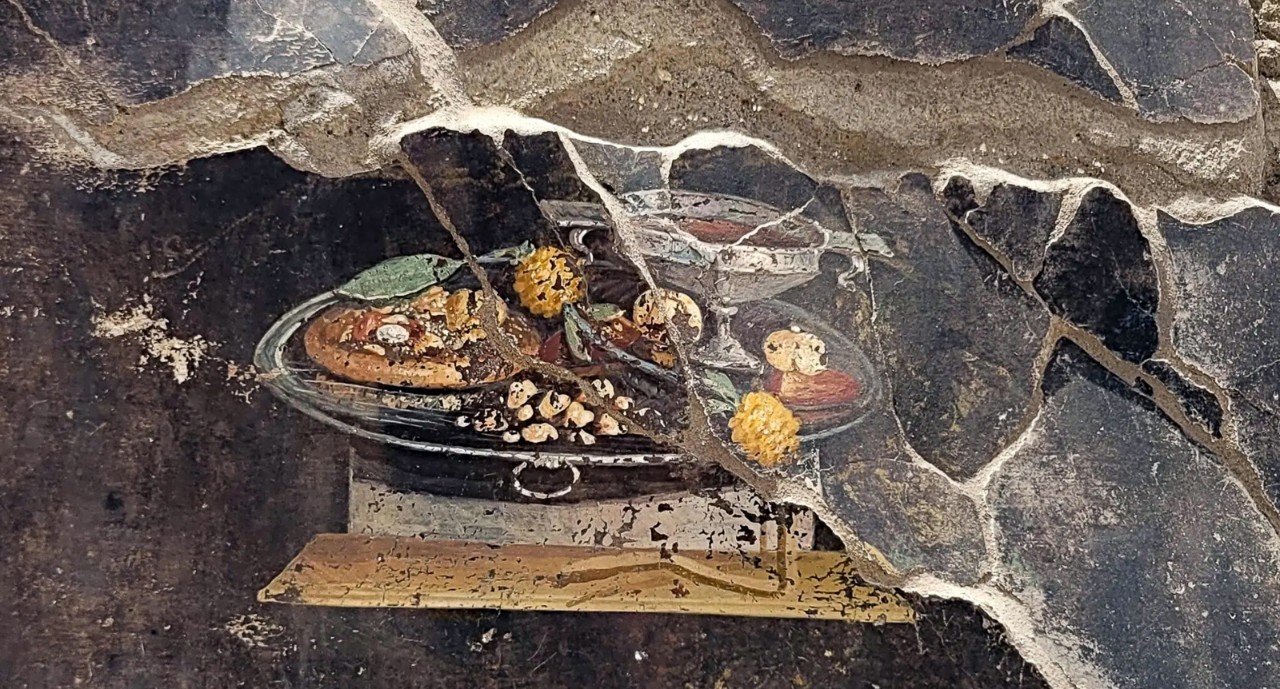 A painting depicts a silver tray of food. 