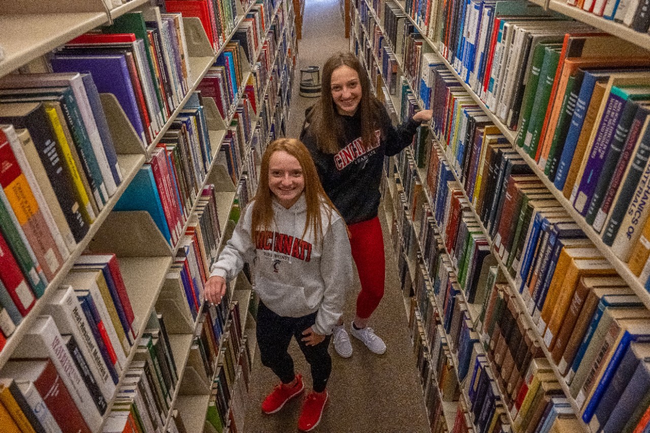 two people in library stacks