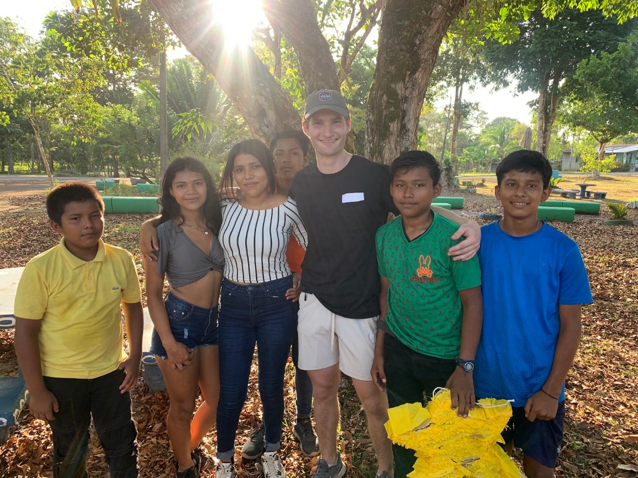 Sam poses with children in Costa Rica 