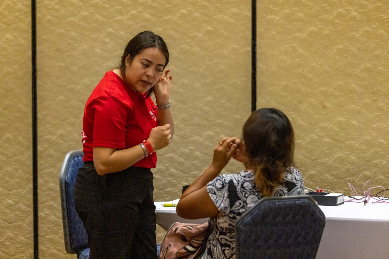 Student assists with hearing aid