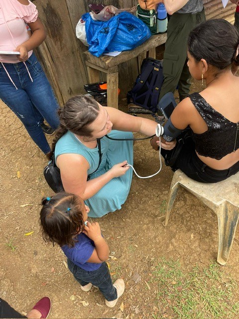 Student takes blood pressure of a child in Costa Rica