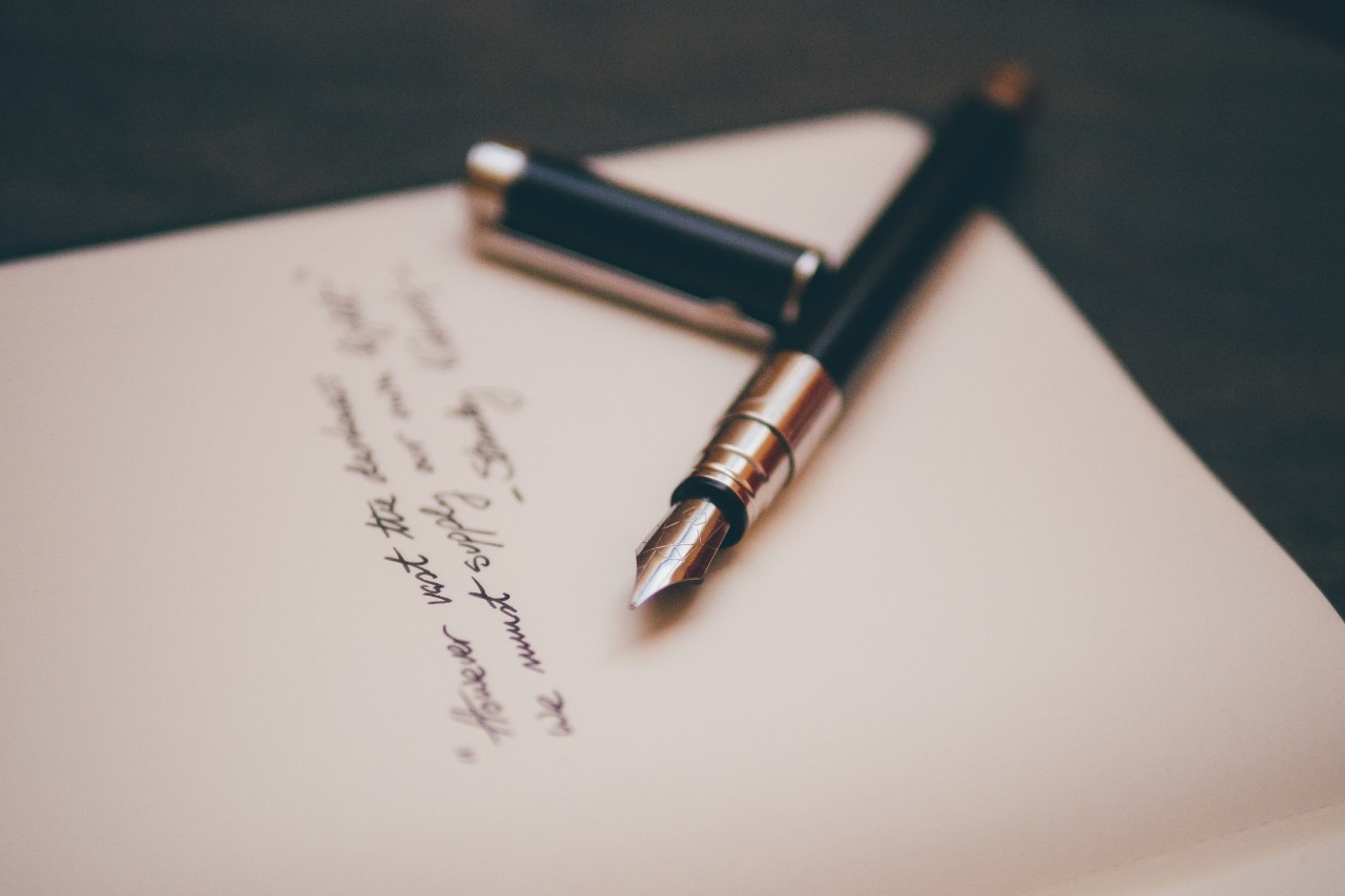 pen and paper with script writing