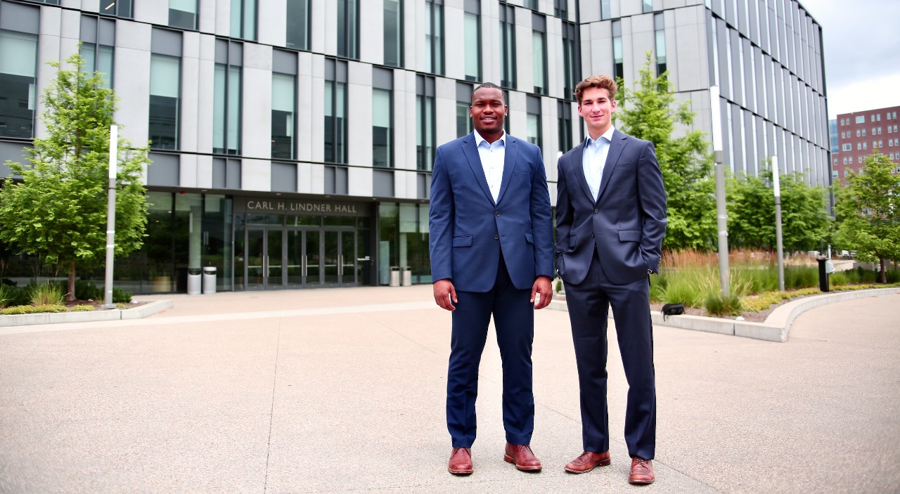 UC business students Sharif Johnson and Patrick McNamara stand outside UC's Lindner College of Business.
