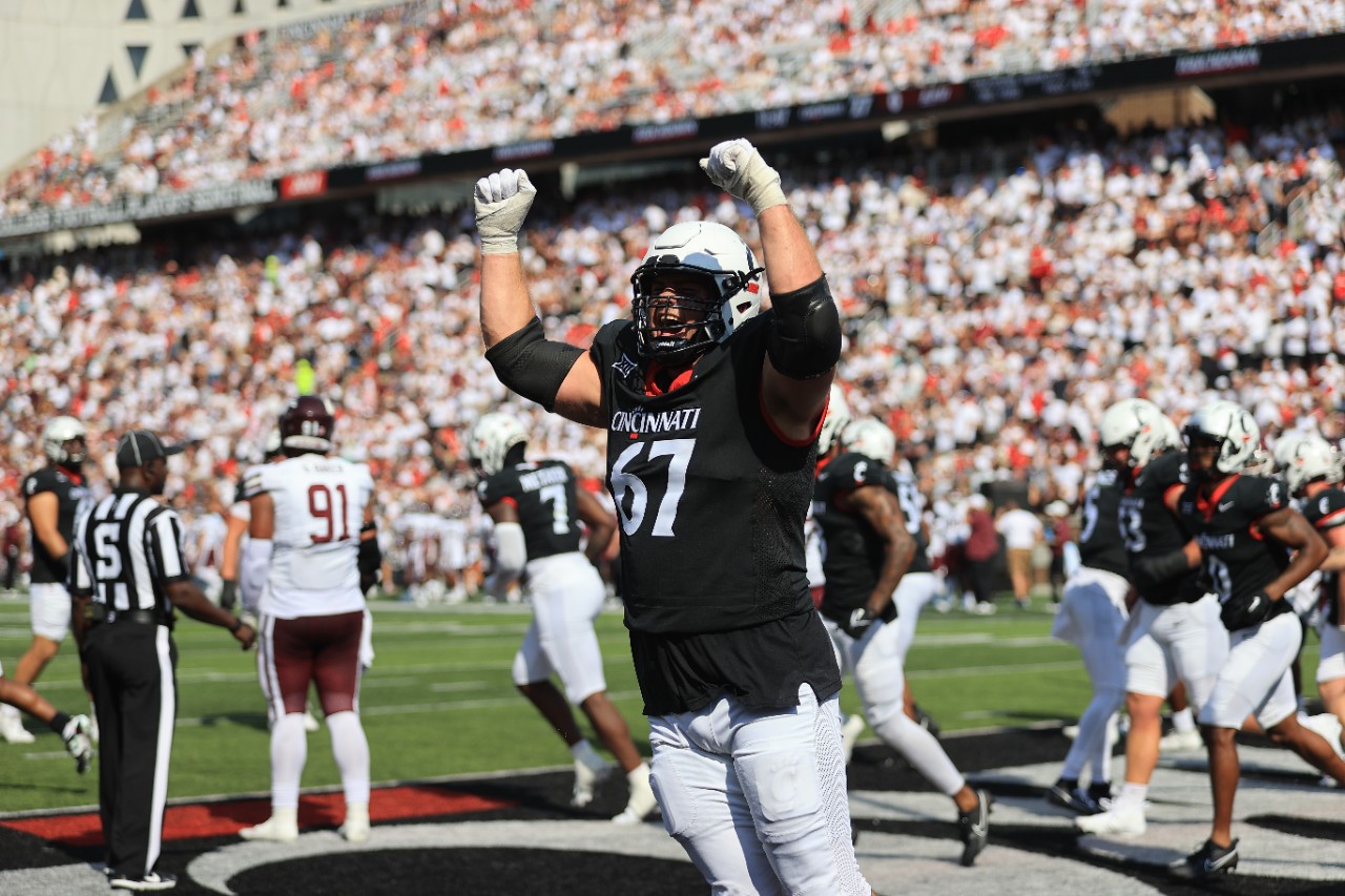 Image of UC football game in which Bearcats defeated Eastern Kentucky University during the season opener. Football player excited with audience in background
