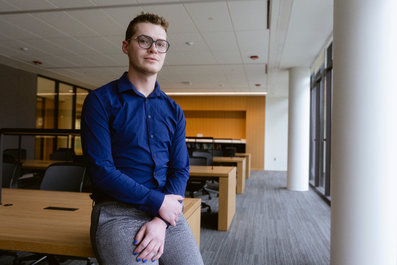 Brendan Mathews sists in the College of Law library reading room.