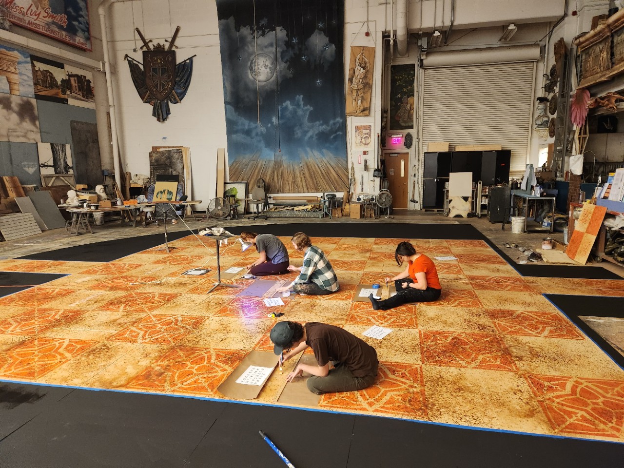 CCM Theatre Design and Production students work to paint the floor used in "Everybody." Left to right: Regan Densmore, Taylor Helms, Moira Seger and Liz Mitan. 