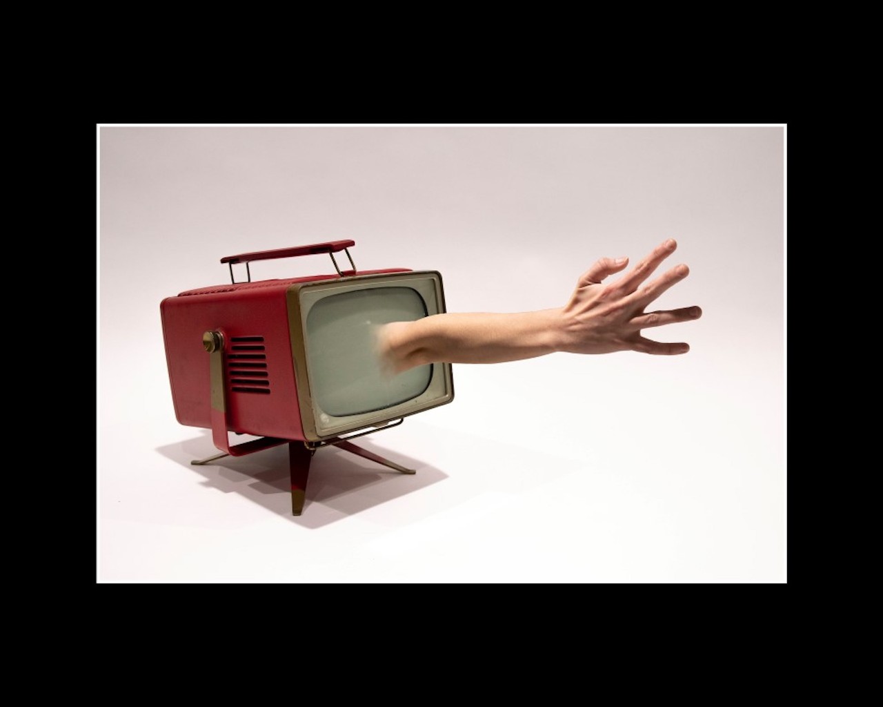 A piece of artwork depicting a hand reaching out of a television
