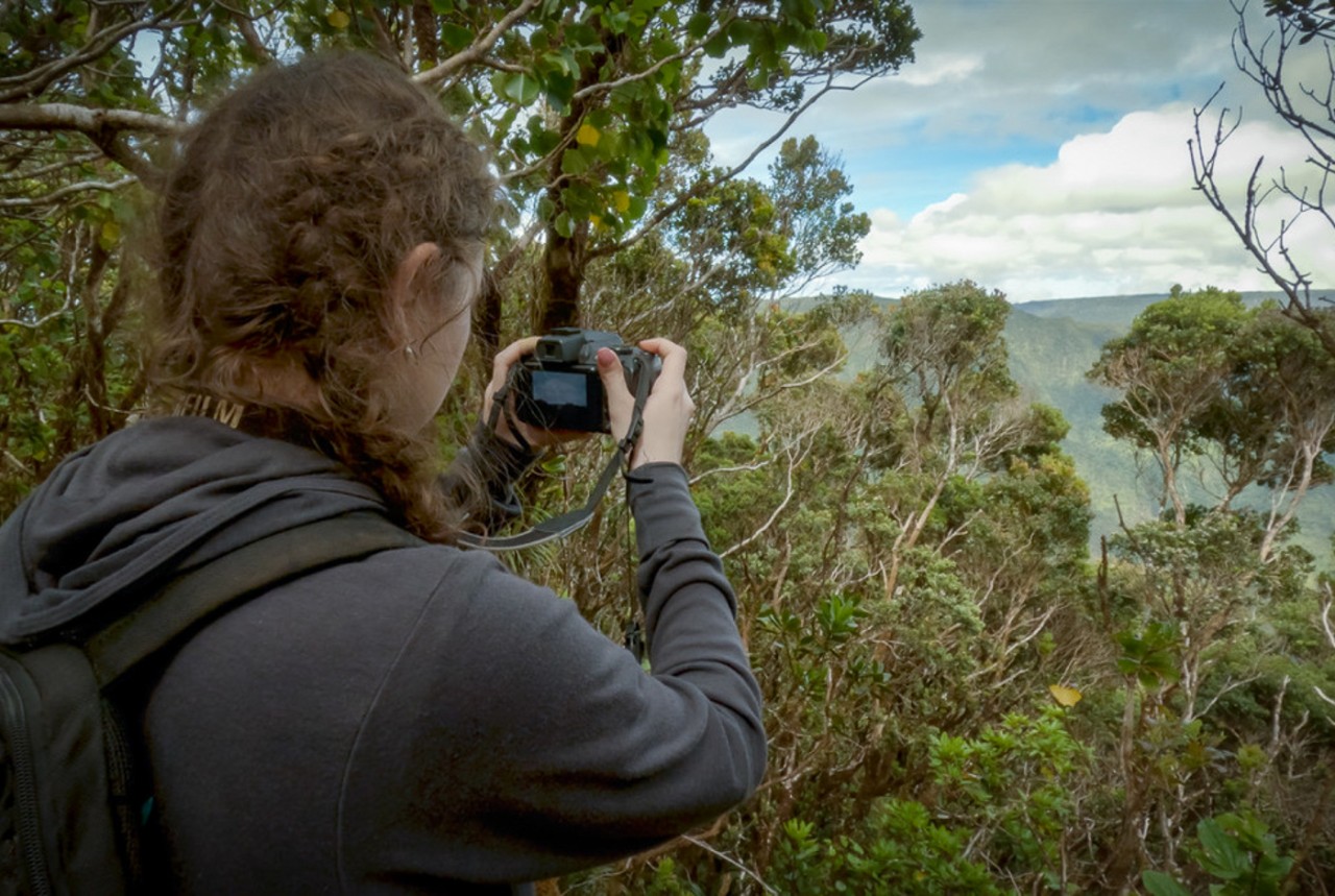 Ella Marcil films a scene for her documentary in a rainforest.