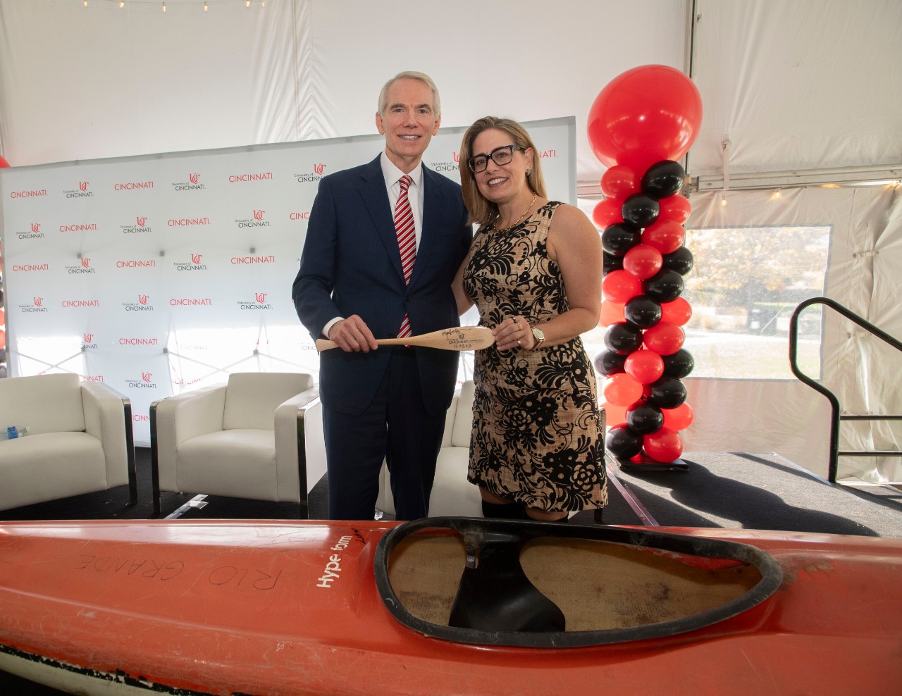 Left to right Rob Portman, Senator, United States of America (OH) and Senator Kyrsten Sinema, AZ posed for a photo with Portman’s Rio Grande kayak after Portman Center for Policy Solutions Panel Question & Answer Segment in tent on Bearcat Commons Monday October 23, 2023. Photos by Joseph Fuqua II
