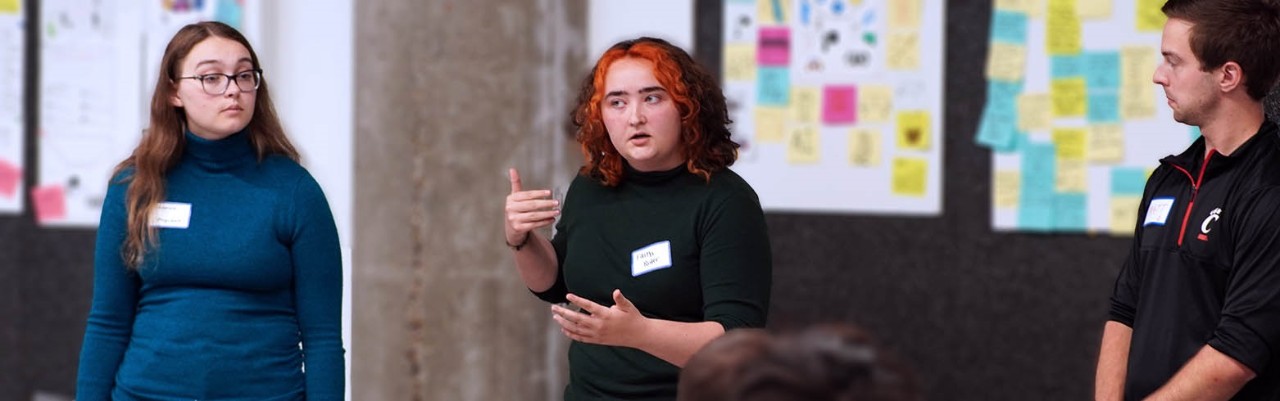 UC students present poster board ideas.