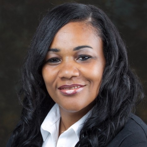 African American woman with black hair, black jacket and white blouse smiles for a headshot