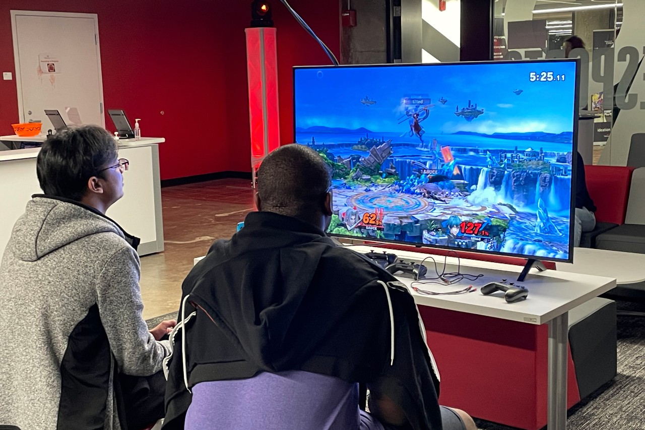 Two men play a video game in UC's ESports Innovation Lab.