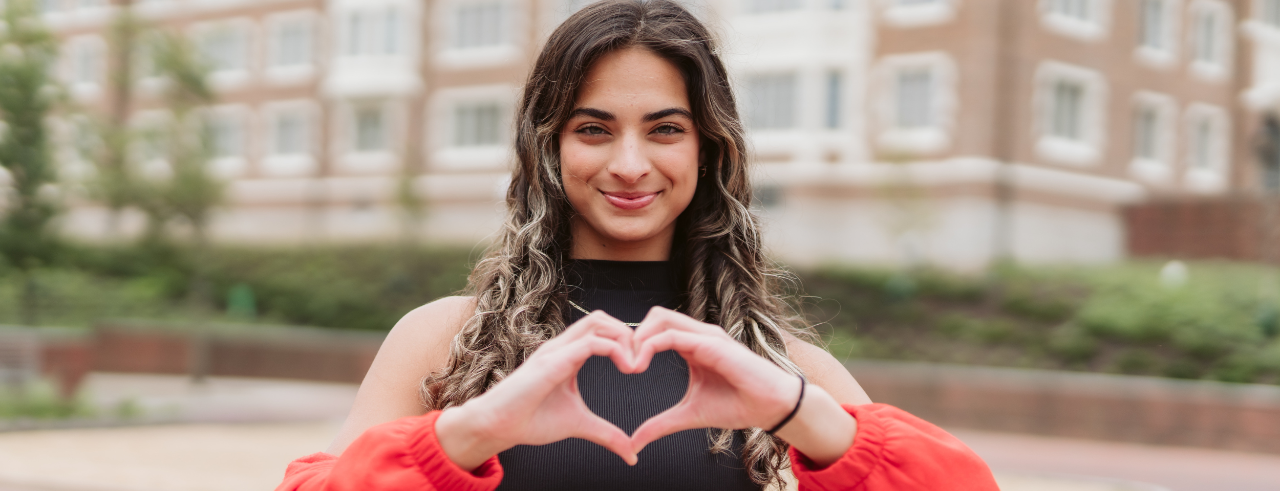 student making a heart with her hands