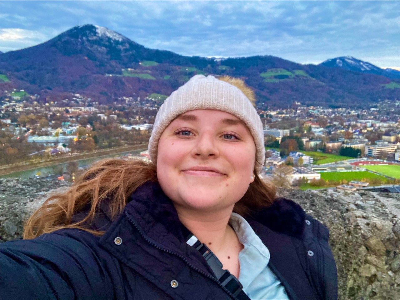 Leah Wolff takes a selfie in front of mountains.