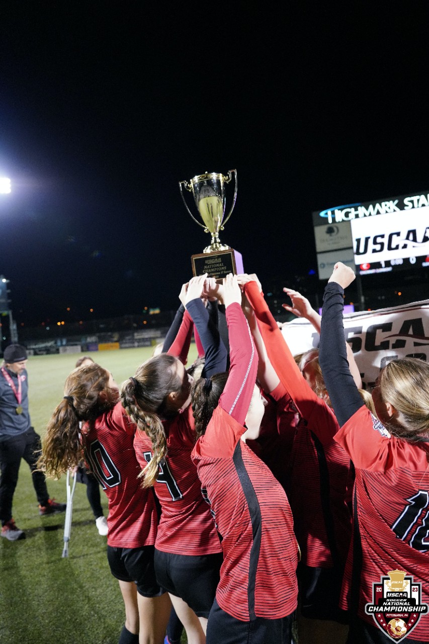 UC Clermont women's soccer team hold the national champion trophy above their heads. 