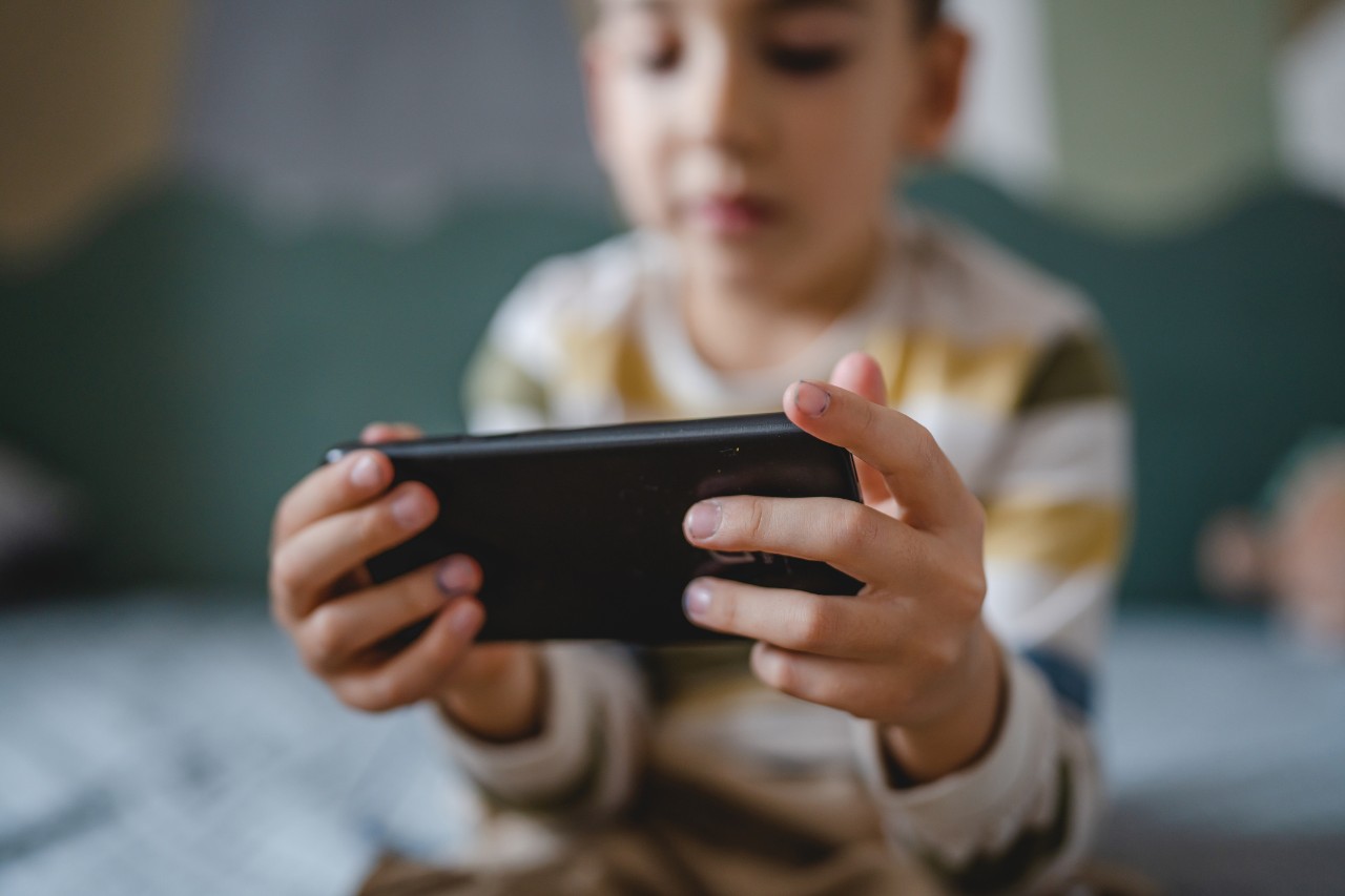 filtered image of child holding a cell phone 