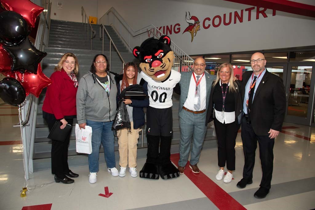 group of parents and administrators posing with student and bearcat mascot