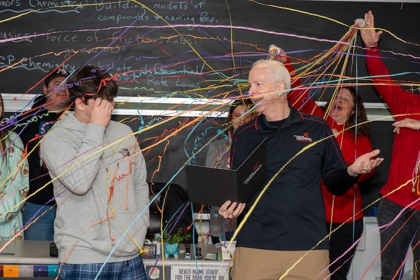New Richmond senior Brodey (left) receives his admission letter and two scholarships from Blaine Kelley, associate director of UC admissions, to cover his first-year tuition to UC Clermont. 
