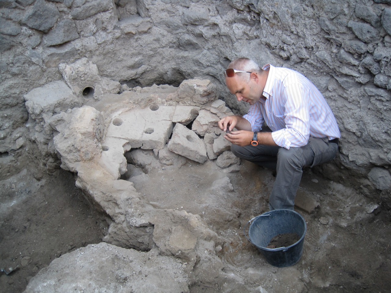 Steven Ellis studies an artifact at an excavation.