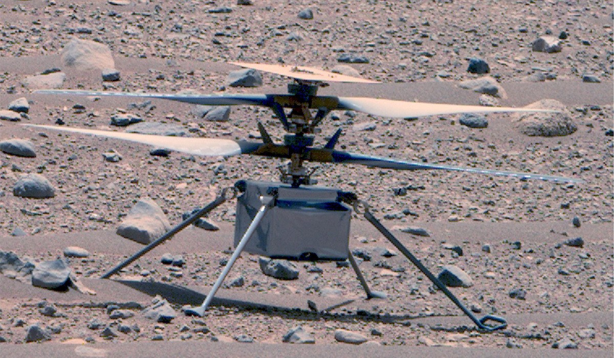 Perseverance captures an image of a dusty helicopter Ingenuity on the rocky surface of Mars..