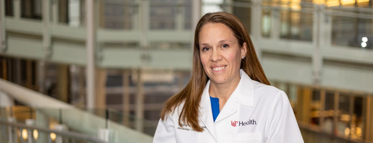 Dr. Wise-Draper stands and smiles on the bridge of the CARE/Crawley Building