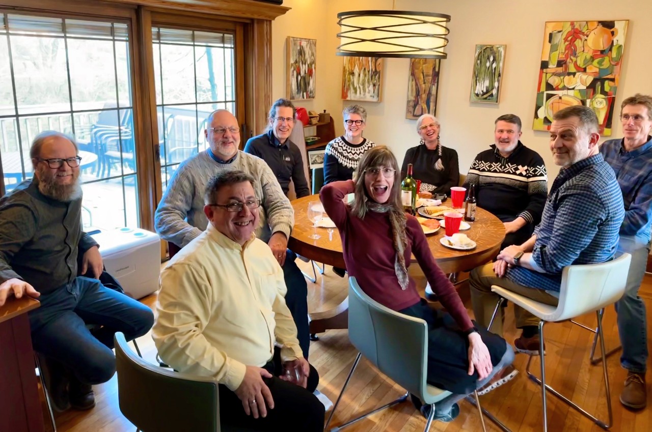UC alum Randal Houts, second from right in back, sits among nine of his longtime bearcat friends around a table.