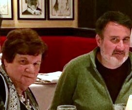 Woman on left sits with her son on right in a restaurant.