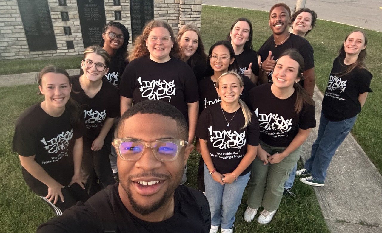 group of students outside of a prison wearing branding t-shirt that say Inside-Out