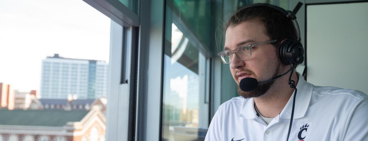 CCM student Ethan Herzog in the broadcasting booth at Nippert Stadium