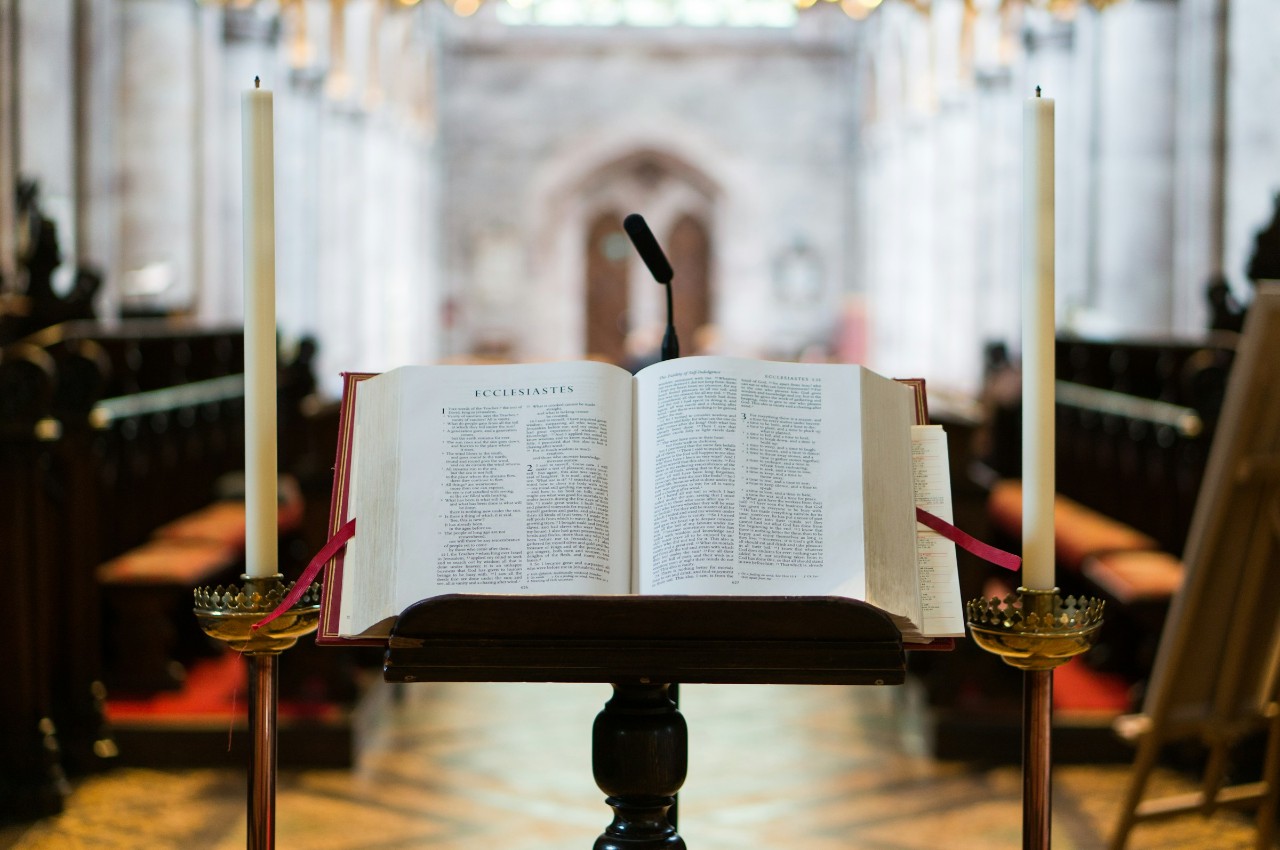 open bible at church with mic and candles