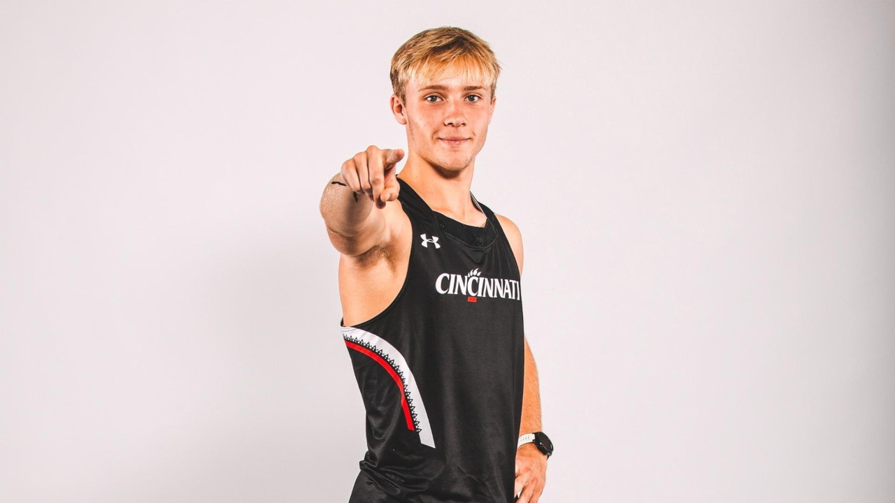 Seth Elking in UC track uniform pointing at camera