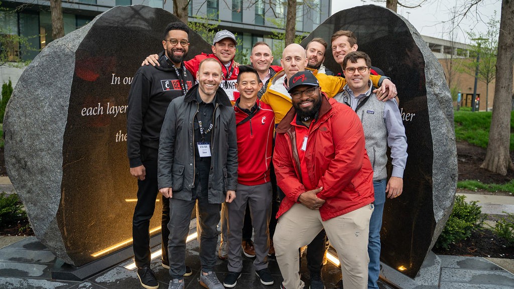 Group of people in front of Rock of Truth sculpture.