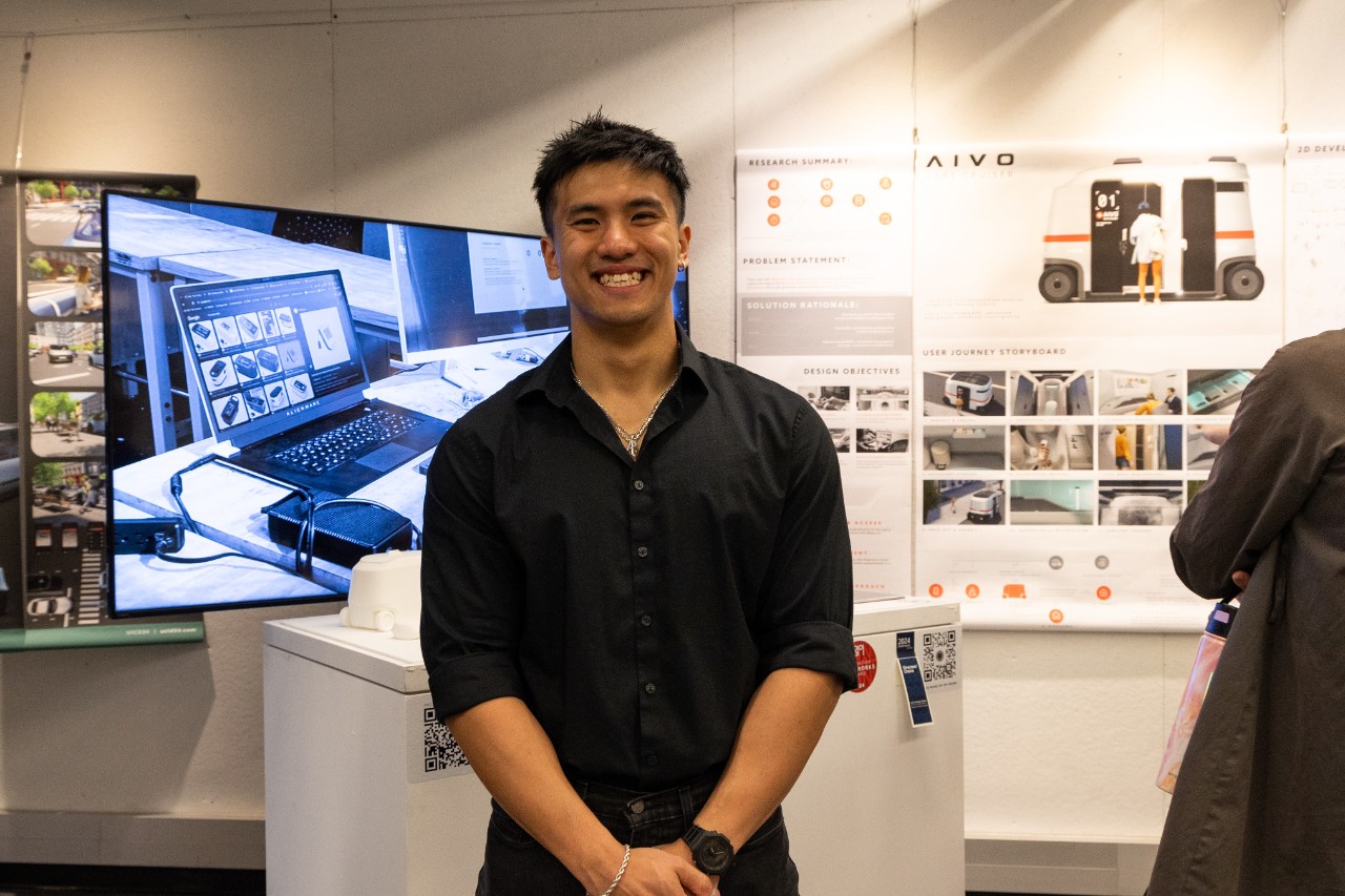 Jimmy Tran, Industrial Design senior smiling with his award winning capstone project.