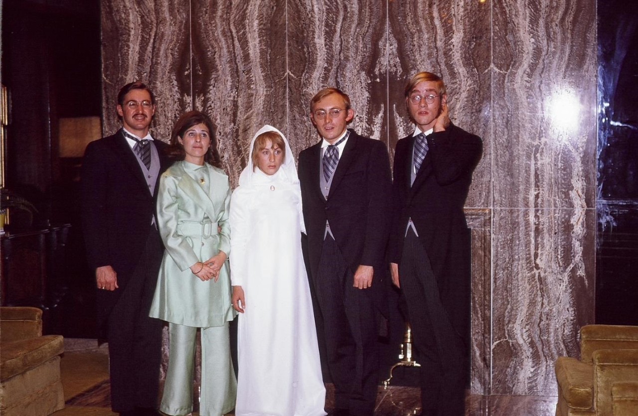Group of five people in a wedding photo.
