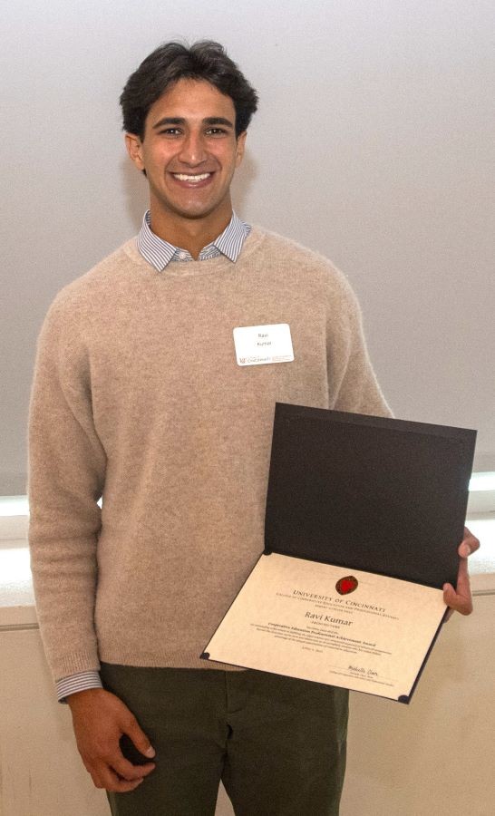 a young man holding an award certificate