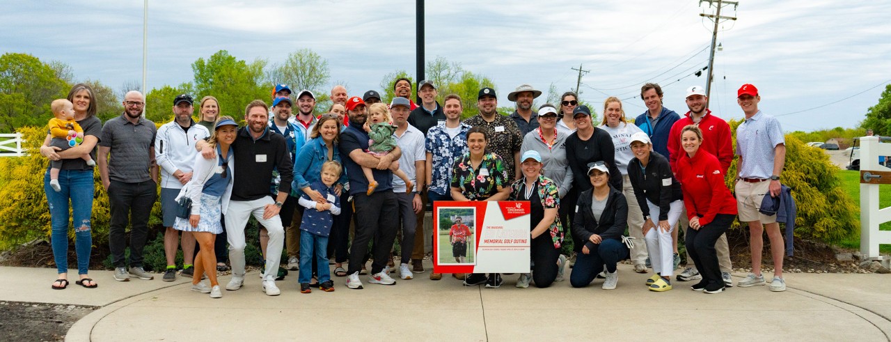 golf outing attendees gathered with a sign of Ed Latessa